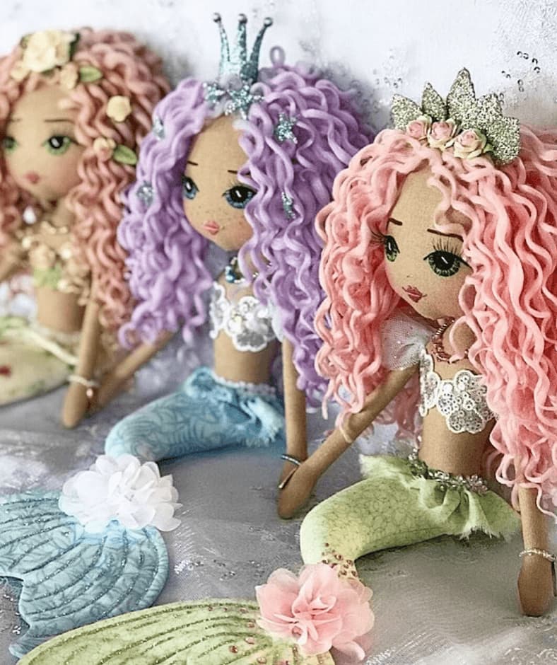 three handmade mermaid dolls with pastel rainbow tails, long curly hair and mermaid crowns