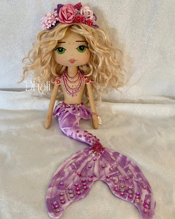 Handmade mermaid doll with purple tail and fuchsia pink sequin and bead detail. Featuring a flower mermaid crown with glitter leaves, hand embroidered face featuring green eyes