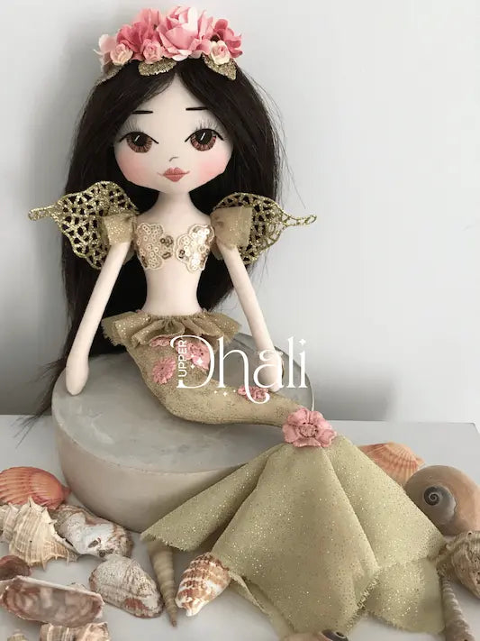 Handmade mermaid doll with golden mermaid tail and pink detail, golden bodice and glittered wings, long dark brown hair and a beautiful mermaid crown featured hand glittered leaves and pink flowers