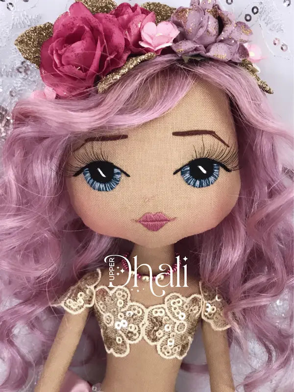 Purple and gold handmade mermaid doll with hand embroidered blue eyes with eyelashes, long mauve mermaid hair and gold glitter and pink flower mermaid crown