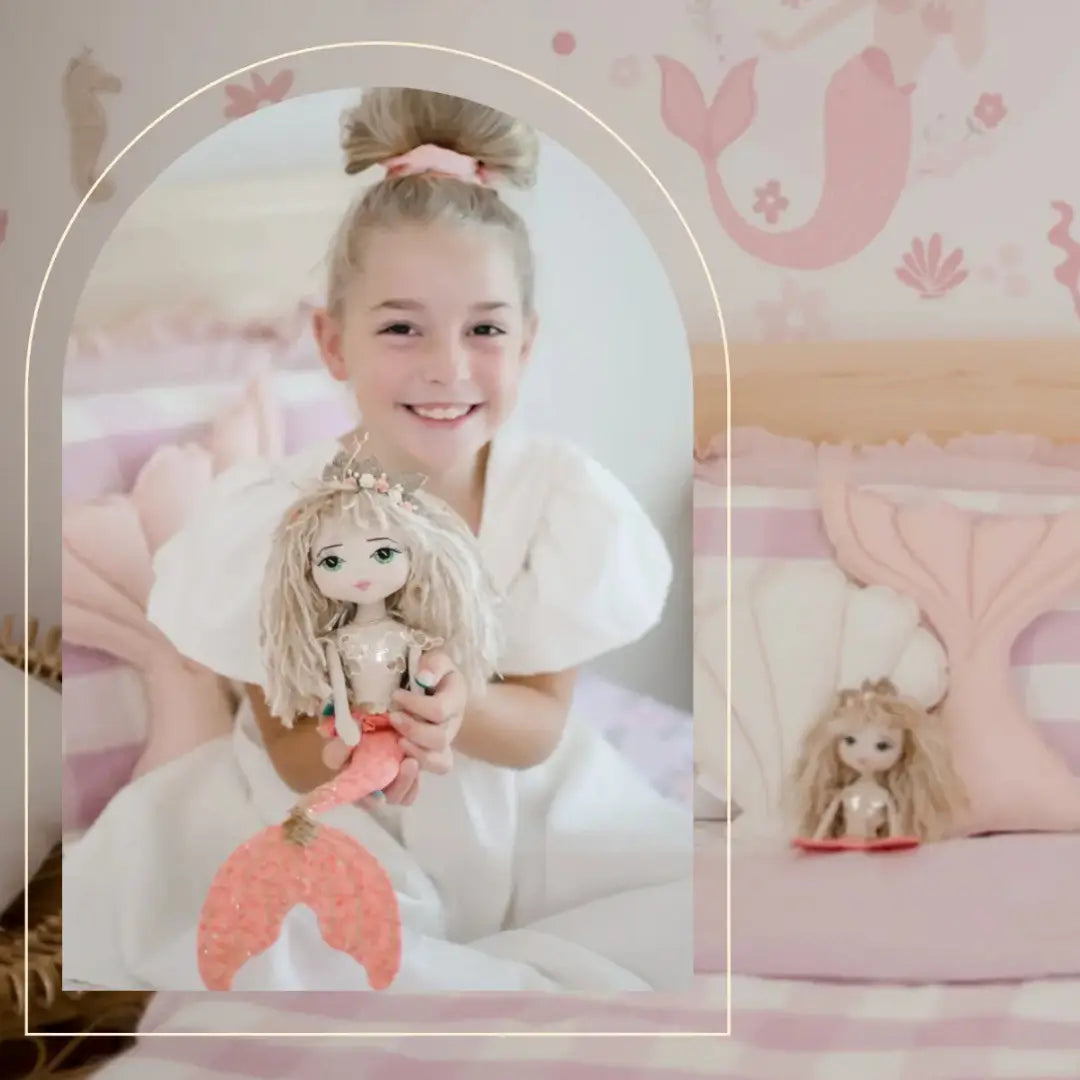Young girl holding a handmade mermaid doll