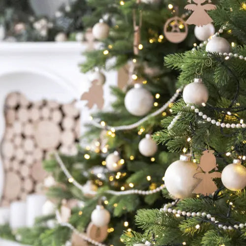 christmas tree with white and wood decorations and golden twinkle lights