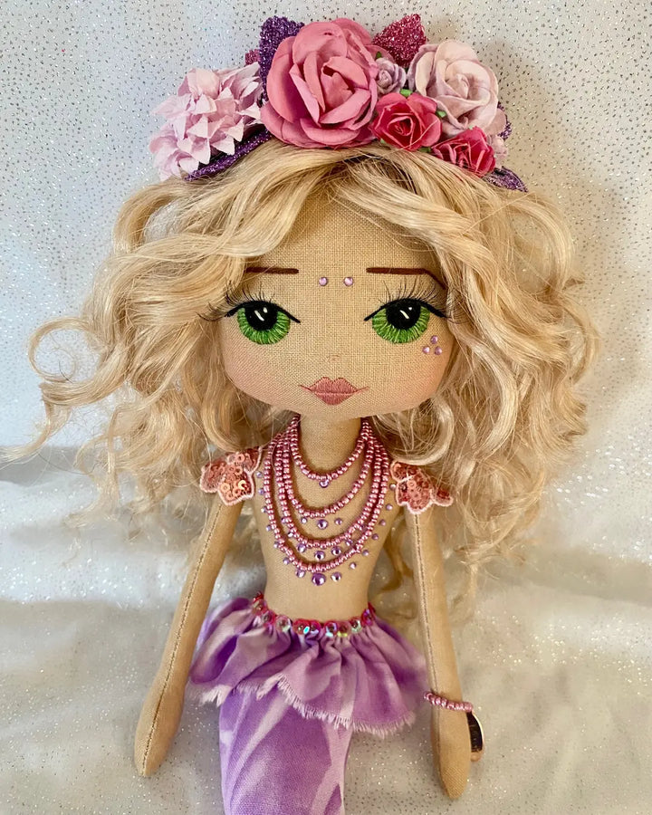 Handmade mermaid doll with purple tail and fuchsia pink sequin and bead detail. Featuring a flower mermaid crown with glitter leaves, hand embroidered face featuring green eyes