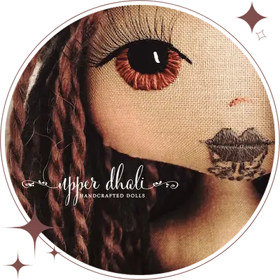 Maori girl personalised handmade doll close up image of hand embroidered face featuring brown eyes, 3 dimensional eyelashes and moko tattoo