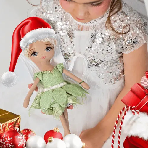handmade fairy doll wearing a red santa hat and surrounded by red and white christmas baubles, presents & santa sack