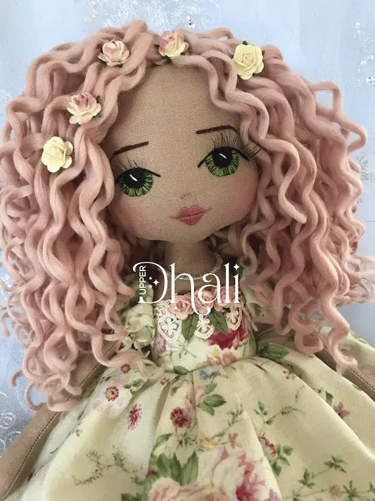 Beautiful handmade doll featuring long pink hand rolled curls, hand embroidered green eyes and a creamy floral lecien fabric vintage inspired children's dress