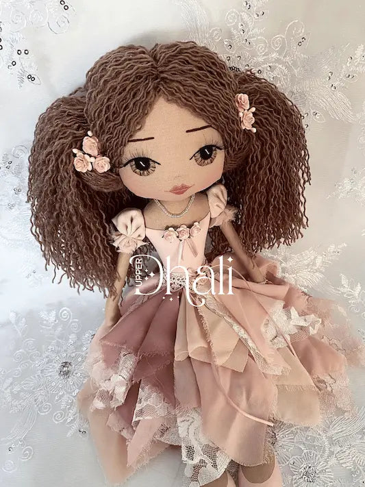 Shabby Chic vintage style handmade doll in pink tones, mulberry paper rose detail and long brown curly vintage style pony tail hairstyle. Brown hand embroidered face featuring 3d eyelashes.