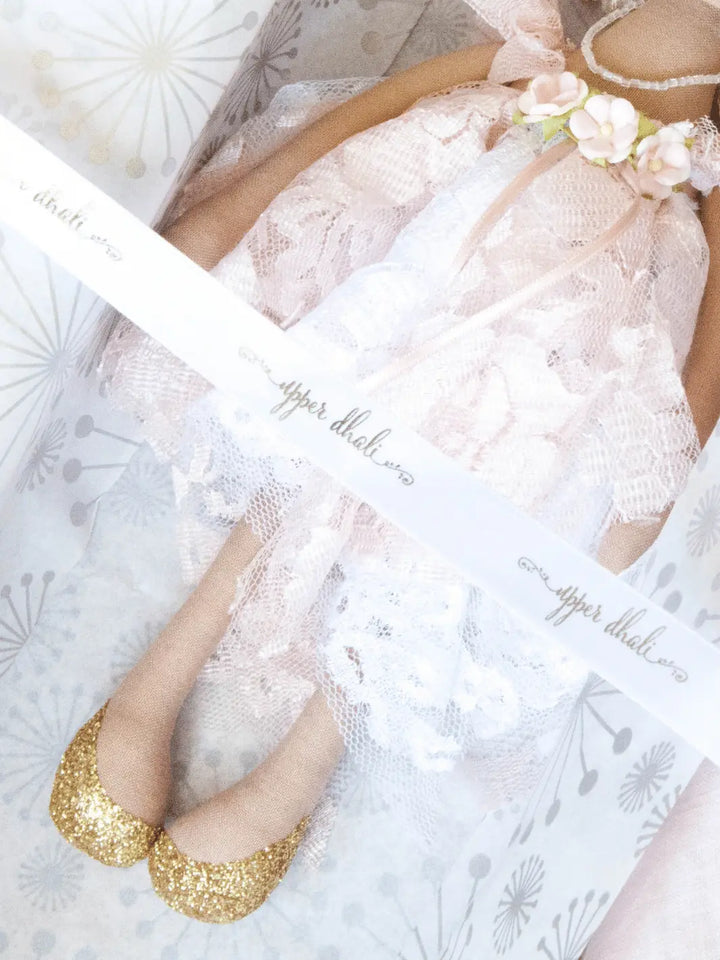 handmade doll with white and pink lace dress, gold glitter shoes and upper dhali branded white ribbon