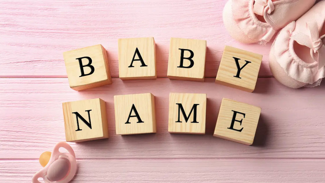 wooden blocks spelling out baby name on pink background