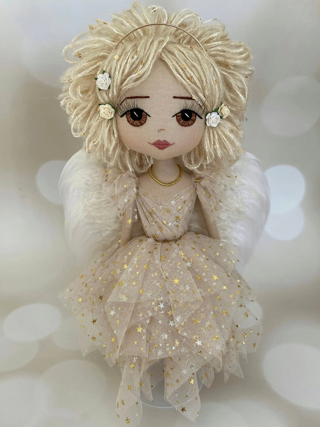 Textile doll with blonde hair and a star-patterned dress on a soft background