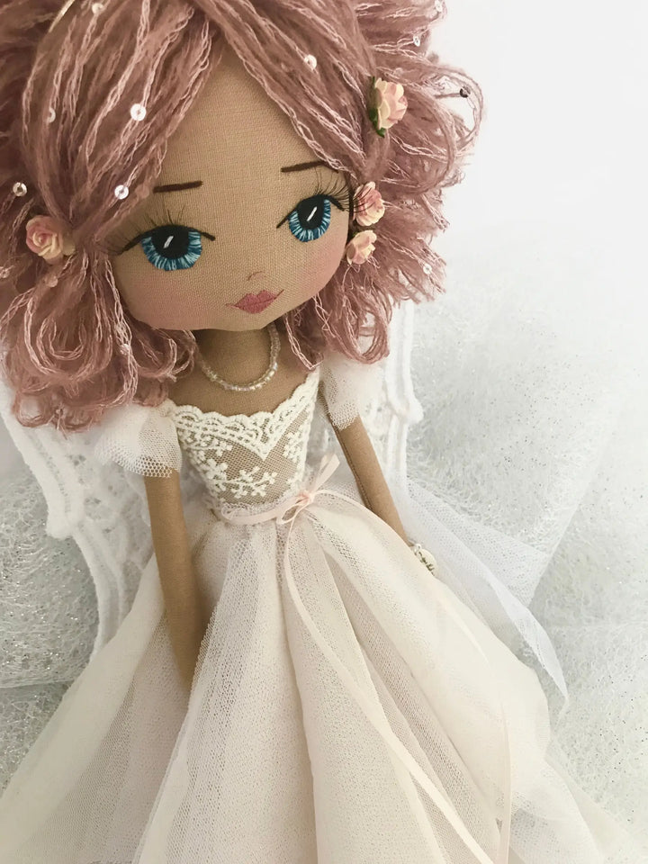 Doll with pink hair and a white dress on a light background