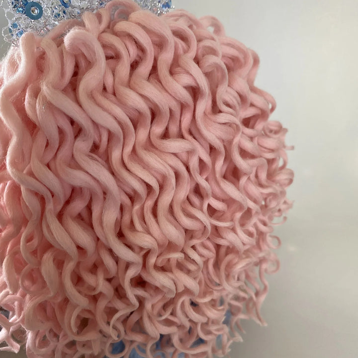 Close-up of Mirren’s hand-rolled pastel pink curls, showing the soft texture and intricate styling.