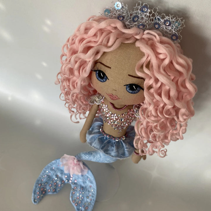 Top-view of Mirren the mermaid doll, highlighting her curls, tiara, and the upper details of her design.