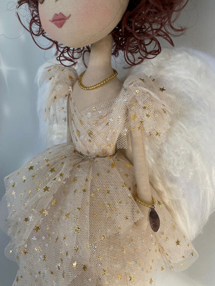 Close up detail of gold star tulle dress on angel keepsake doll