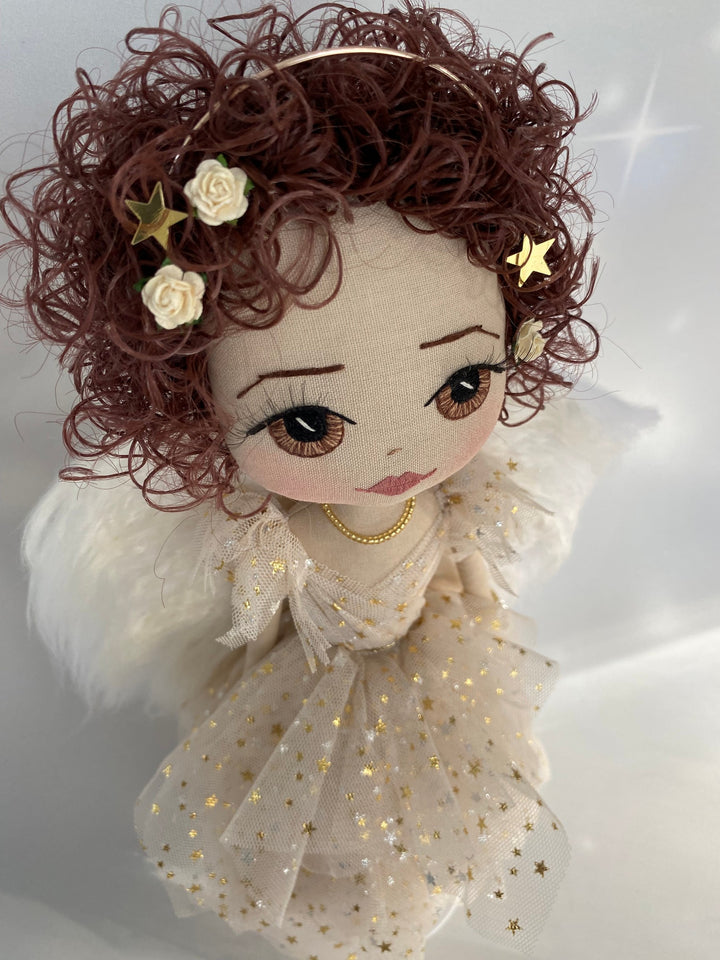 Golden angel keepsake doll with brown curly hair and gold star tulle angel gown showing curly brown hair and cream rose detail in her hair