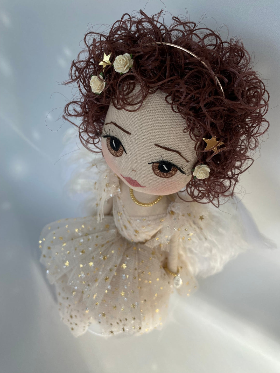 Angel keepsake doll with brown curly hair, golden halo and flowers and gold stars in her hair