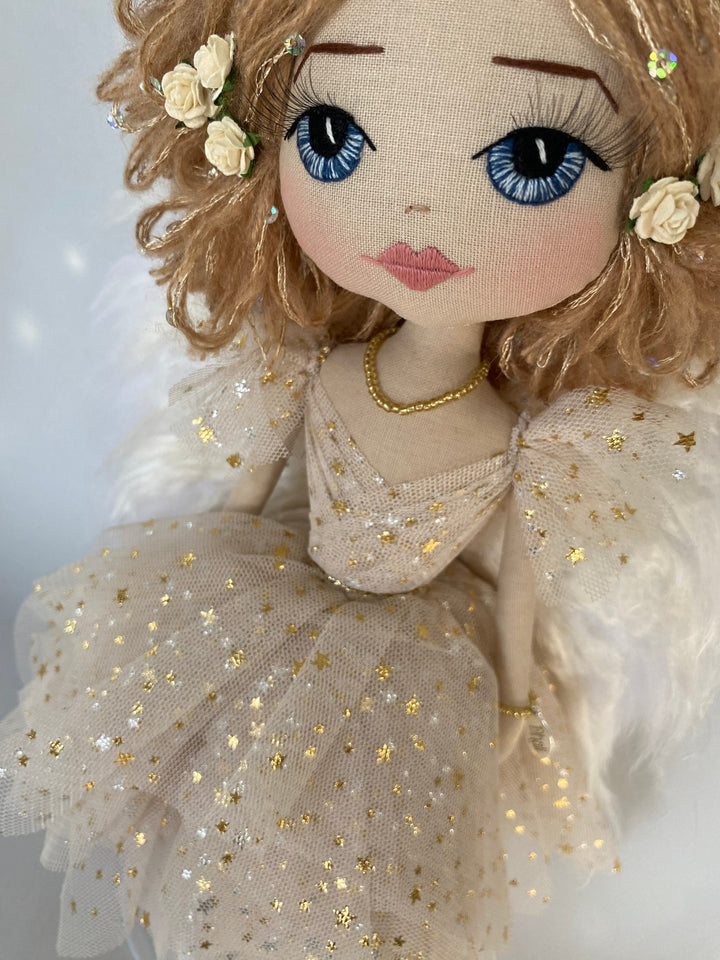 Christmas angel doll close up of hand embroidered blue eyes and golden angel gown