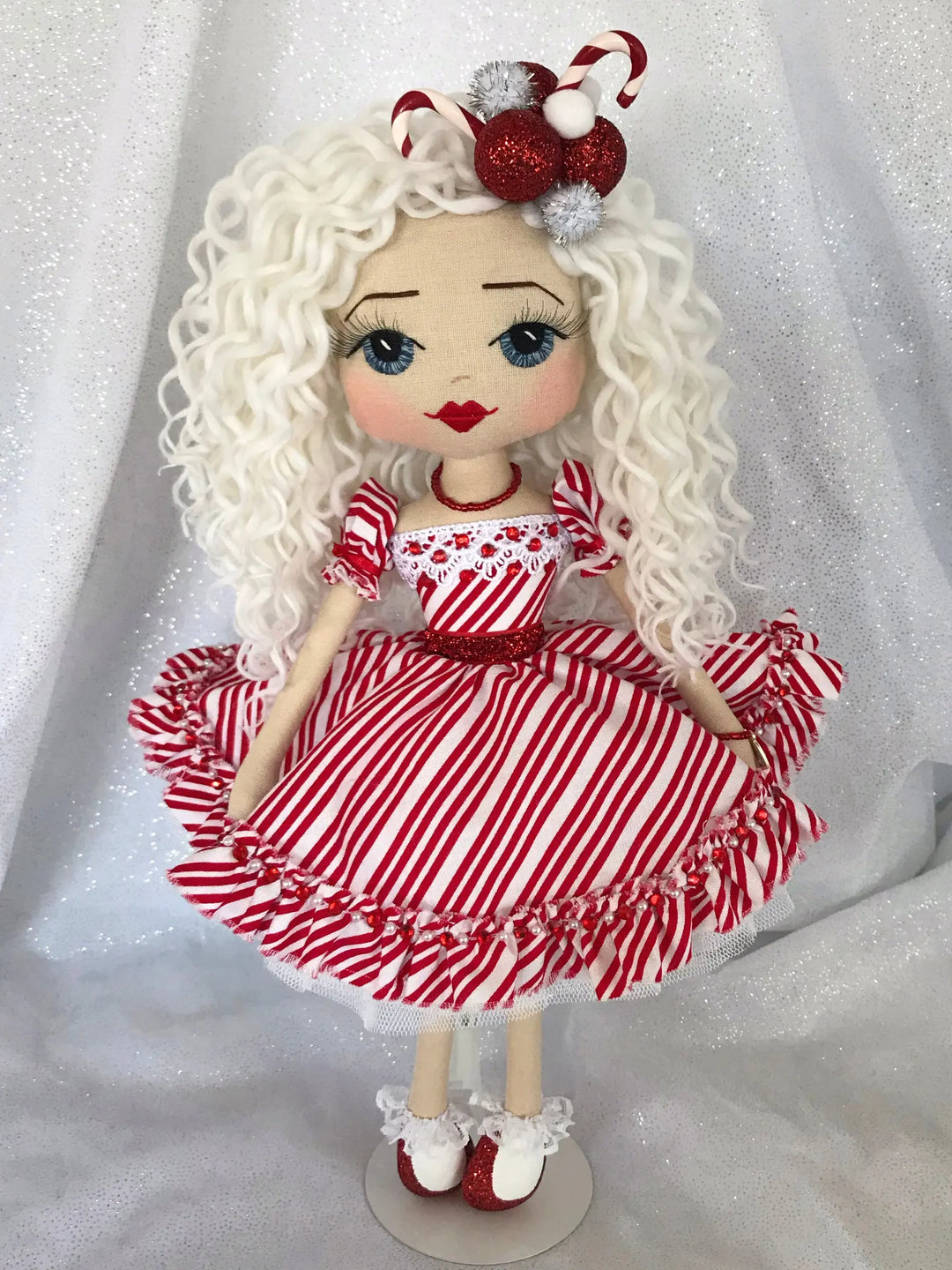 Handmade doll wearing a red & white stripe dress with candy cane headpiece. Made by Upper Dhali.