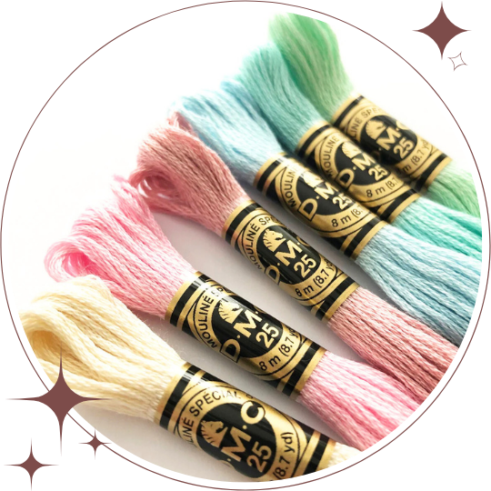 Four skeins of embroidery floss in pastel colors on a white background
