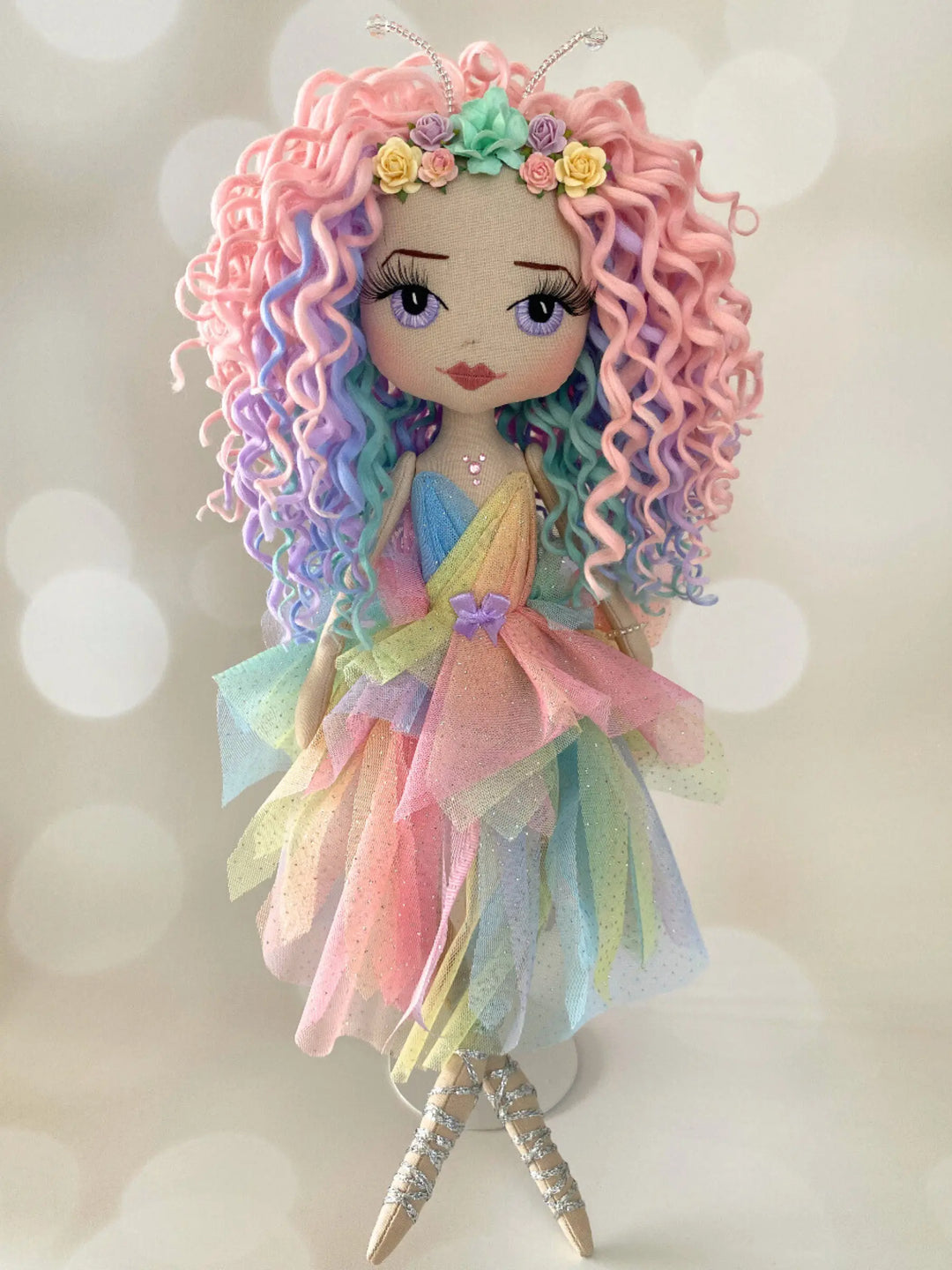 fairy doll wearing a pastel rainbow dres made by Upper Dhali