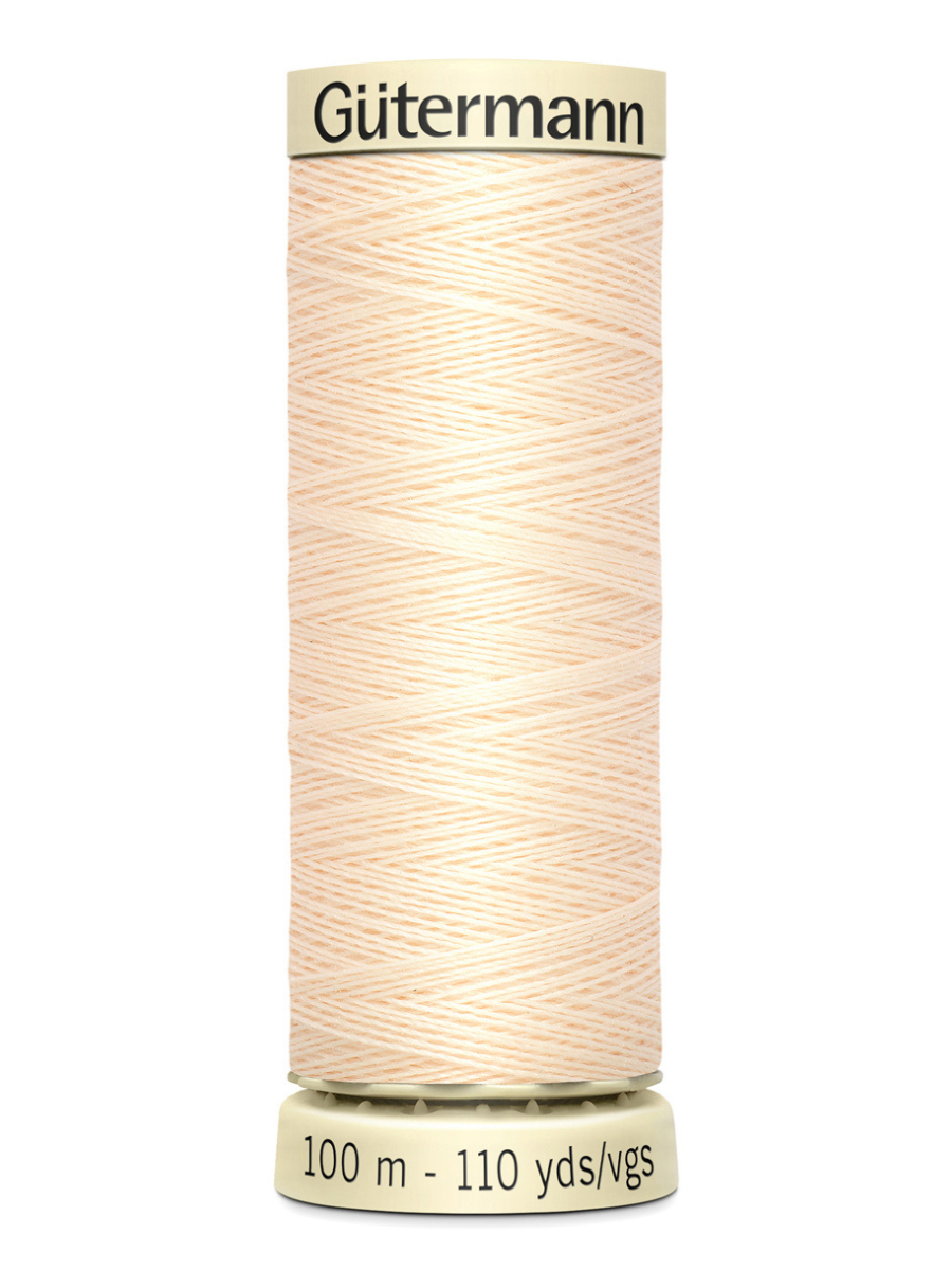 Cream Gutermann thread spool on a white background
