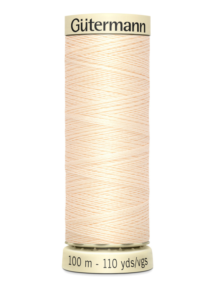 Cream Gutermann thread spool on a white background