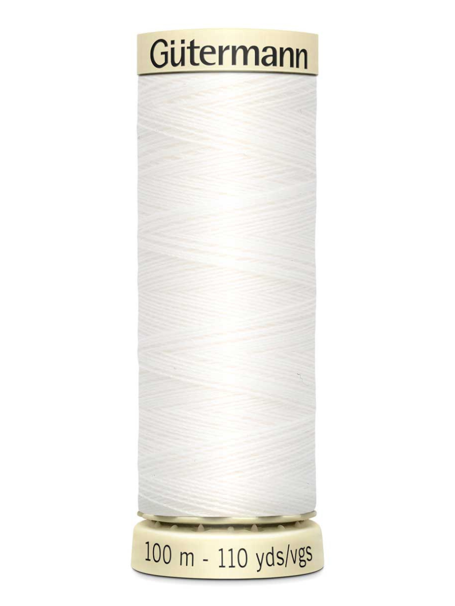 Spool of white Gutermann thread on a white background