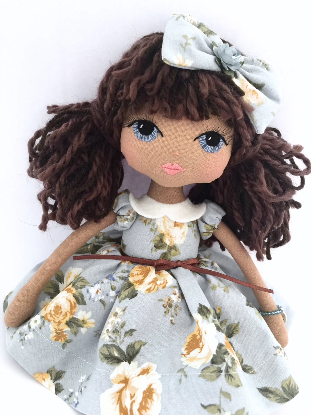 Handmade doll wearing a miniature replica Lacey Lane dress in blue and yellow florals, made by Upper Dhali