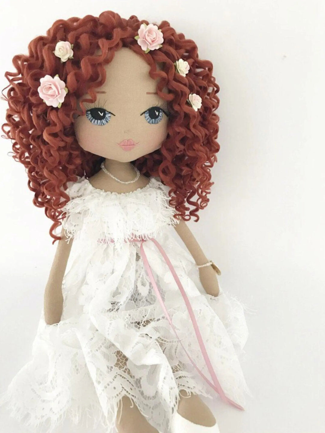 Handmade doll wearing a white chantilly lace dress with auburn curls made by Upper Dhali