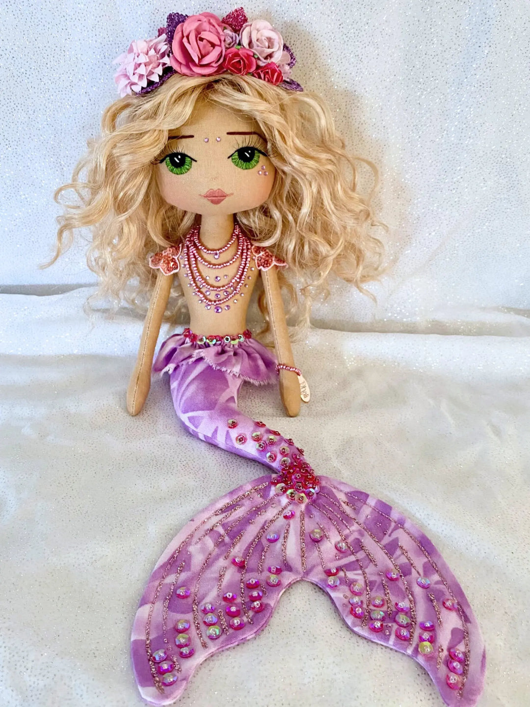 Mermaid doll with blonde hair, pink flowers, and a purple tail by Upper Dhali