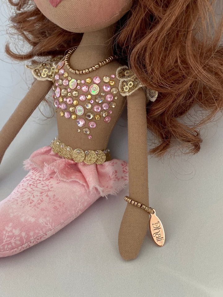 Doll with decorative outfit and pink shoes on a white background