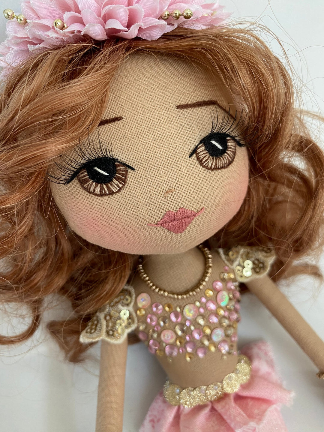 Detailed doll with pink and gold outfit on a white background