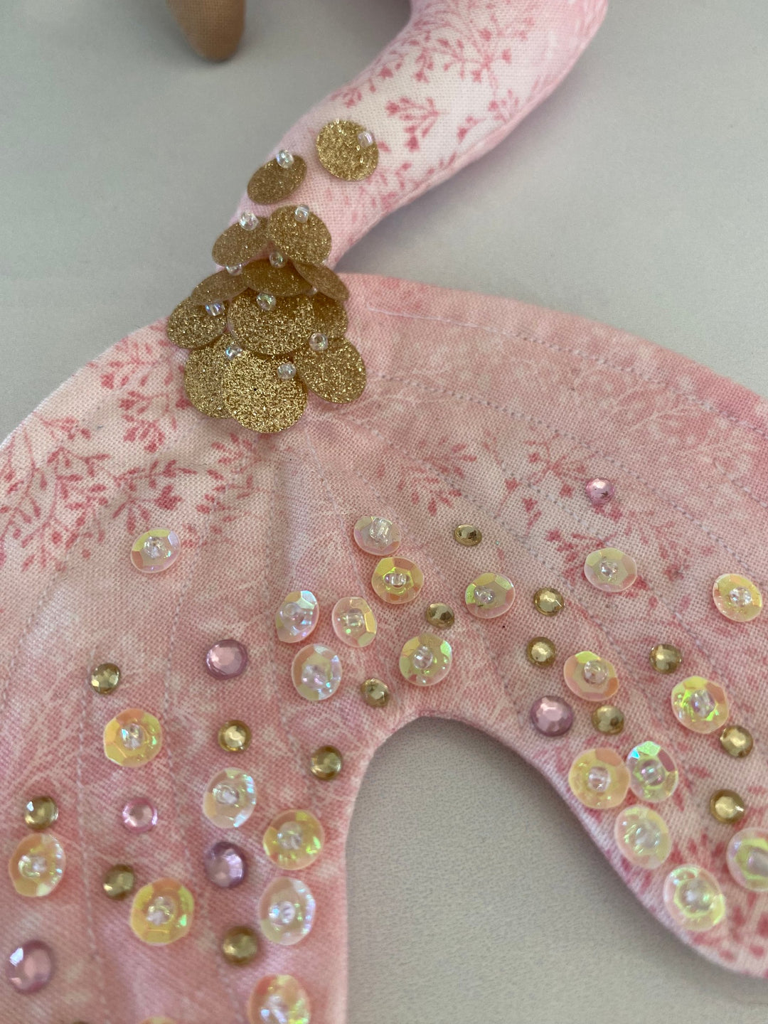 Decorative pink hanger with sequins and beads on a light background