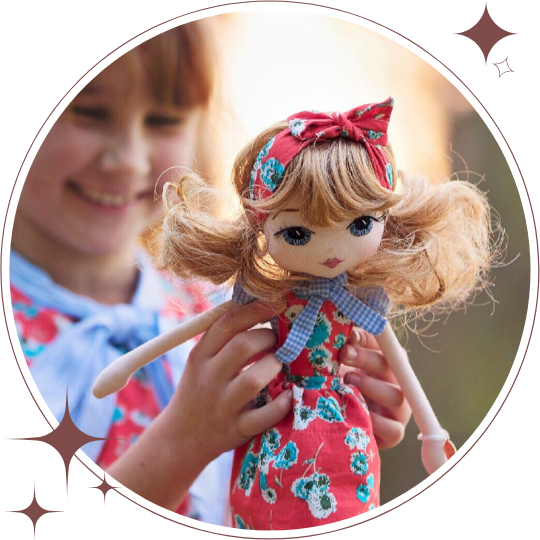 Child holding a doll with a floral dress and red headband, with a blurred background