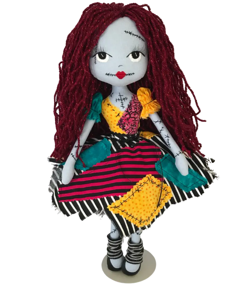 Sally Finkelstein inspired handmade doll with blue skin and long red hair. Featuring a rag doll dress made from scraps of material in yellow, pink, teal & black and white stripe. Hand embroidered white eyes, red lips with black scar stitching detail.