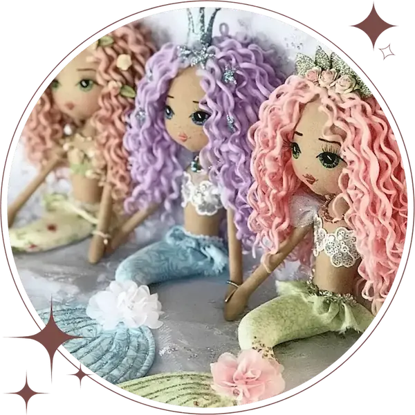 three mermaid dolls sitting in a row; rainbow colours of purple, blue, green and pink with glitter mermaid crowns