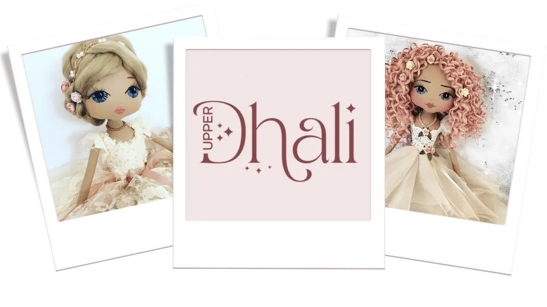 three polaroid images; the left showing a handmade doll with blonde hair and neutral tone lace dress; the middle is the Upper Dhali logo; the third is a handmade doll wearing neutral tone tulle dress, with pink curly hair