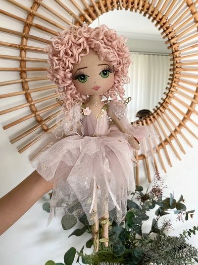 Pink handmade fairy doll with embroidered face. Featuring gold fairy wings, green eyes, pink hand rolled curly hair