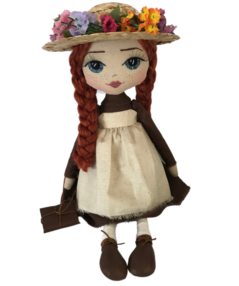 anne of green gables handmade doll with red plaits and a blue eyes wearing a flower hat, a brown dress with calico apron and holding a book stack. 