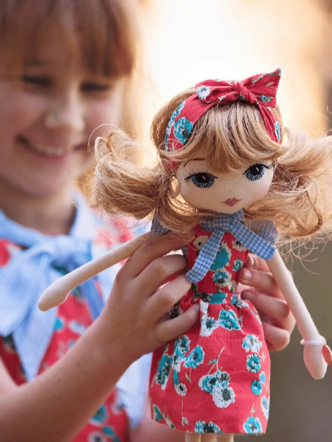 Young girl wearing red Lacey Lane dress with her Upper Dhali personalised mini-me handmade doll wearing the same outfit
