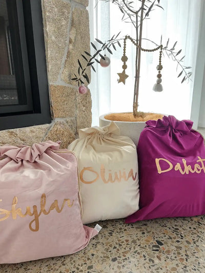 blush ivory and magenta velvet santa sacks under minimalist christmas tree